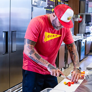 Learn about HGUNO® Refrigeration and our Concept Solutions for Fast Casual - Person Cutting Food on Cutting Board